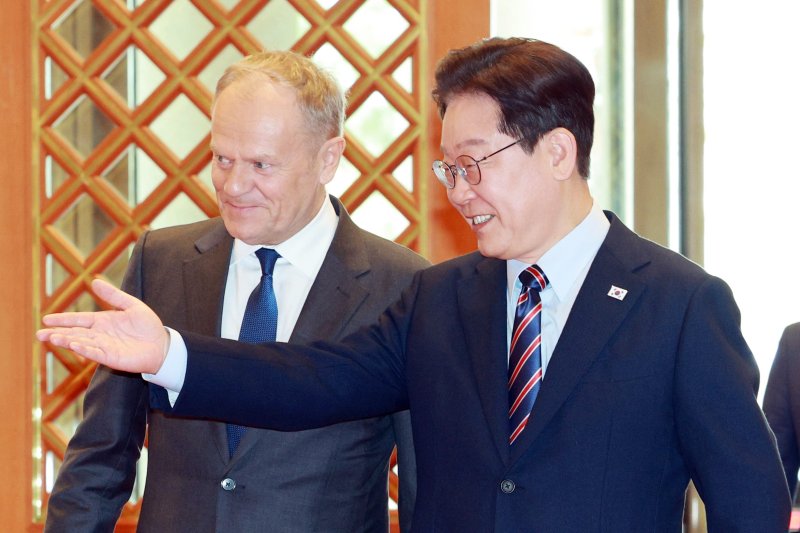 이재명 대통령이 13일 청와대에서 공식 방한한 도날트 투스크 폴란드 총리와 방명록 서명식장으로 이동하고 있다. 연합뉴스