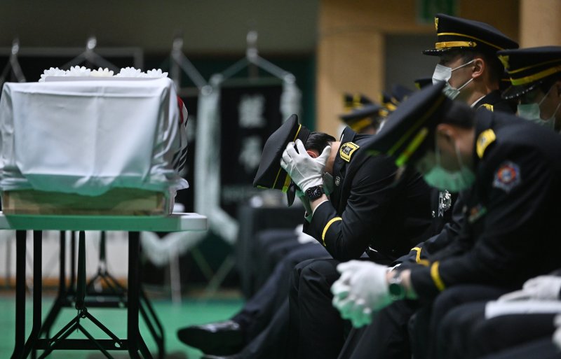 [완도=뉴시스] 이영주 기자 = 14일 오전 전남 완도군농어민문화체육센터에서 열린 고(故) 박승원(44) 소방경과 고 노태영(30) 소방교의 영결식에서 고인의 영현을 운구한 한 소방관 동료가 괴로워하고 있다. 2026.04.14. leeyj2578@newsis.com