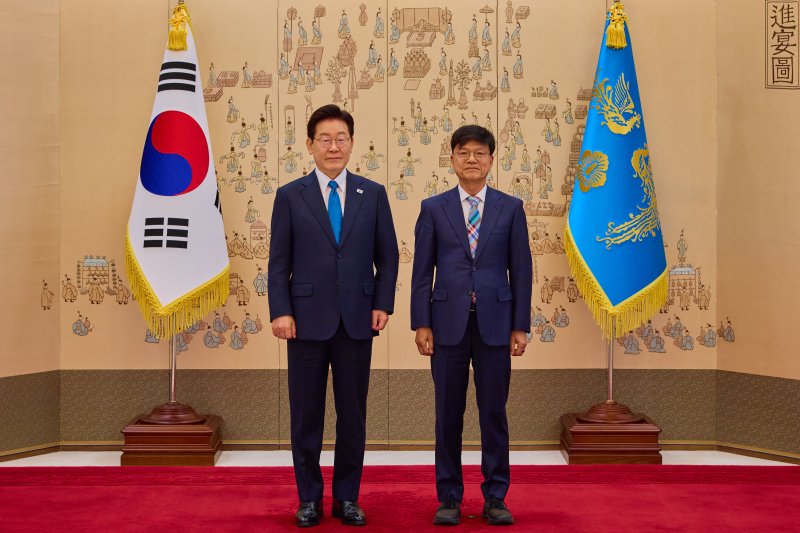 이재명 대통령이 15일 청와대에서 규제합리화위원회 제1차 전체회의에 앞서 이병태 규제합리화위원회 부위원장에게 위촉장을 수여한 뒤 기념촬영을 하고 있다. 청와대 제공