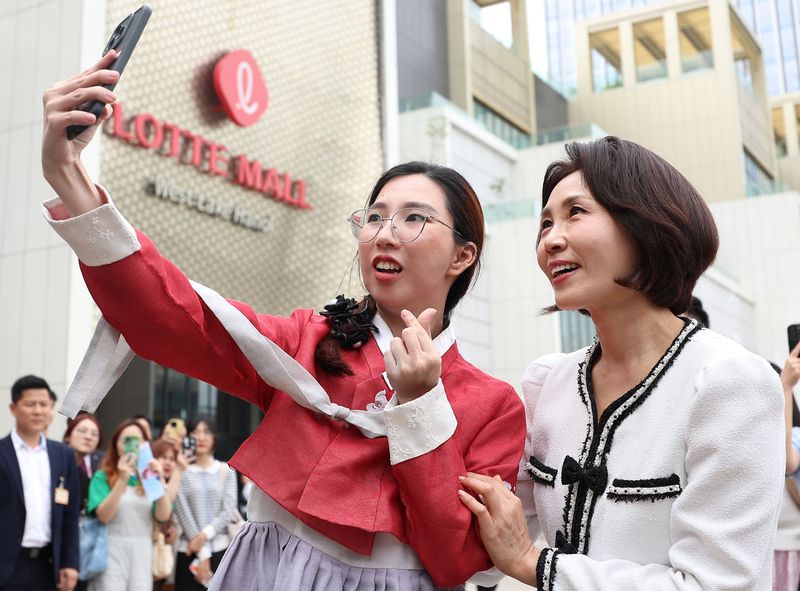 이재명 대통령과 베트남을 방문 중인 김혜경 여사가 23일(현지시간) 하노이 서호 롯데몰에서 열린 K문화관광대전에서 한복을 입은 또우띠 떰씨와 기념촬영을 하고 있다. 뉴스1