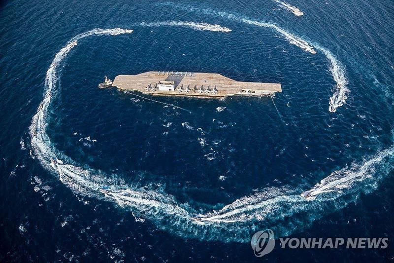 모형 항공모함을 포위한 이란의 고속공격정 훈련 (출처=연합뉴스)