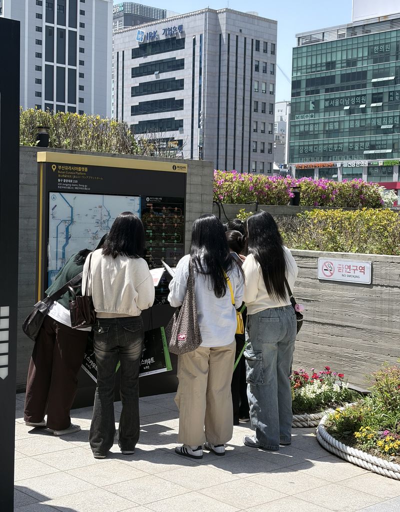 24일 ‘더 스카우트 in 부산’ 프로그램 참여자들이 첫 코스인 부산역 광장에서 퀴즈를 풀고 있는 모습. 부산관광공사 제공