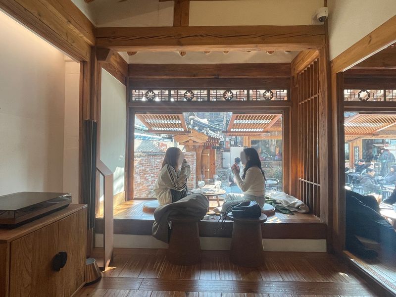 스타벅스 대구종로고택점의 고택에선 사람들이 신발을 벗고 바닥에 앉아 커피를 마신다. 통창 너머 마당에서도 사람들은 야외 테이블을 이용할 수 있다. /사진=서윤경 기자