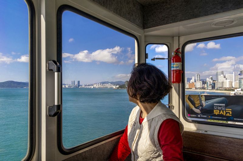 미포에서 청사포를 거쳐 송정을 오가는 해변열차에 탑승한 한 이용객이 부산앞바다 멀리 오륙도 방향을 바라보고 있다. 해운대블루라인파크 제공