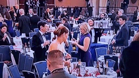 지난 26일(현지시간) 미국 백악관 기자단 만찬장서 총격 사건이 발생한 직후 한 여성이 행사장에 남겨진 와인병을 챙기는 모습. /영상=X 캡처