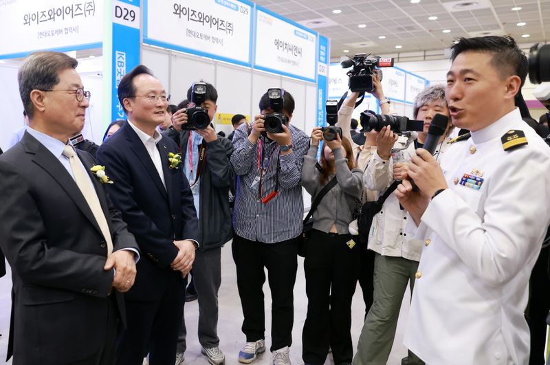 KB국민은행은 27일 서울 강남구 코엑스에서 '2026 제1차 KB굿잡 우수기업 취업박람회'를 개최했다. 이날 행사에서 부스를 찾은 이달곤 동반성장위원회 위원(왼쪽 첫번째)과 이환주 KB국민은행장(왼쪽 두번째)이 설명을 듣고 있다./사진=KB국민은행