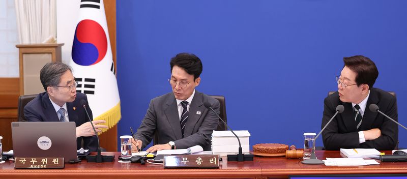 이재명 대통령이 28일 청와대에서 열린 국무회의 겸 비상경제점검회의에서 조현 외교부 장관과 대화하고 있다. 가운데는 김민석 국무총리. 연합뉴스