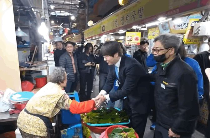 29일 부산 구포시장을 찾은 하정우 전 청와대 AI미래기획수석이 시장 상인과 악수를 나누는 모습. / 영상=온라인 커뮤니티