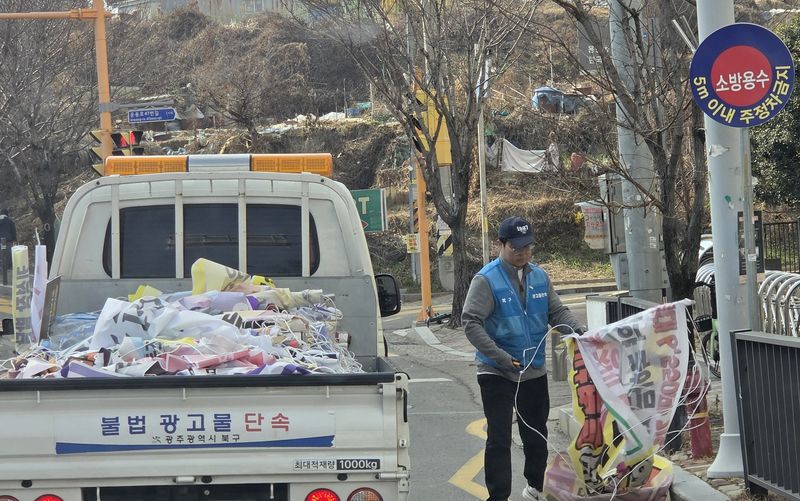 불법 현수막 집중 단속이 시작된 가운데, 광주 북구의 한 도로에서 관계자들이 현수막을 철거하고 있다. /뉴시스