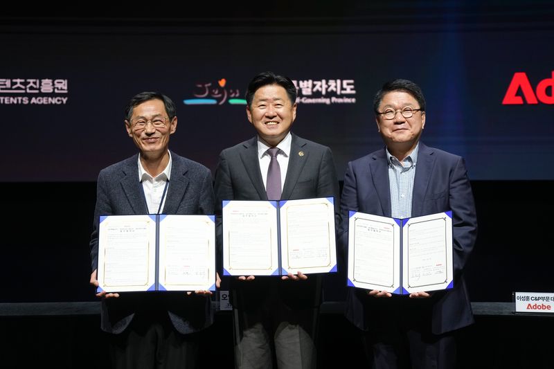 제주콘텐츠진흥원 강민부 원장(왼쪽부터), 오영훈 제주도지사, 이성순 어도비코리아 전무가 지난 3월 17일 제주 비인공연장에서 '생성형 인공지능(AI) 기반 콘텐츠 산업 활성화'를 위한 업무협약을 체결한 뒤 협약서를 들어 보이고 있다. 이번 협약은 생성형 AI 콘텐츠 인재 양성과 지역 콘텐츠 기업의 AI 기술 활용 지원, 글로벌 네트워크 연계 협력을 담고 있다. 제주특별자치도 제공