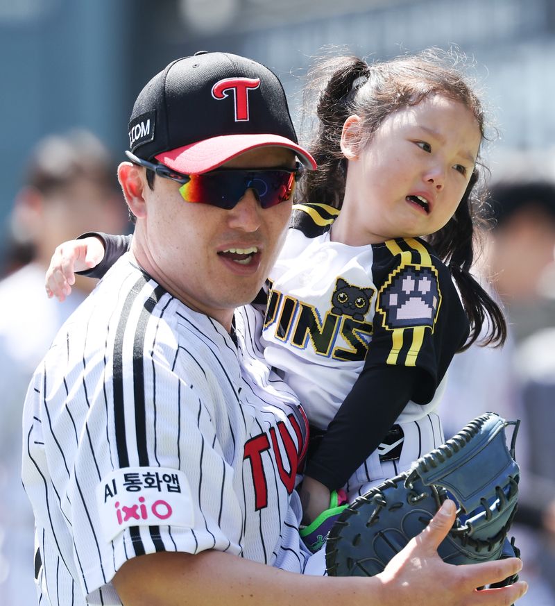 [서울=뉴시스] 최진석 기자 = 5일 서울 송파구 잠실야구장에서 열린 2026 KBO리그 두산 베어스와 LG 트윈스의 경기에서 LG 박동원과 딸 박채이 양이 시구 후 이동하고 있다. 2026.05.05. myjs@newsis.com