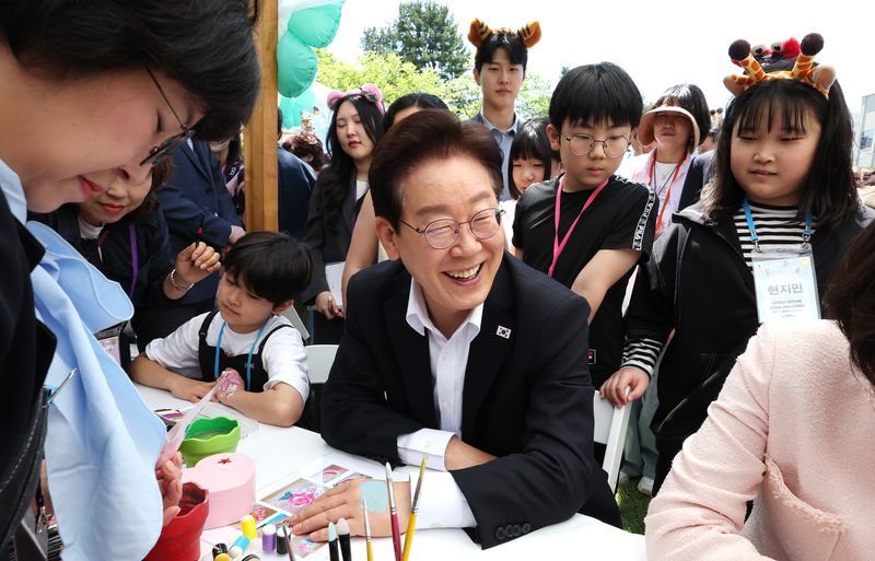 이재명 대통령과 김혜경 여사가 5일 청와대 녹지원에서 열린 2026 어린이날 초청행사에 참석한 어린이들과 함께 손등에 페이스 페인팅을 받고 있다. 2026.5.5 ⓒ 뉴스1 허경 기자