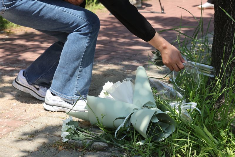 6일 오전 광주 광산구 남부대 인근 피습 현장을 찾은 한 시민이 국화꽃을 내려놓으며 고인의 넋을 기리고 있다. 2026.5.6 ⓒ 뉴스1 조수민 수습기자