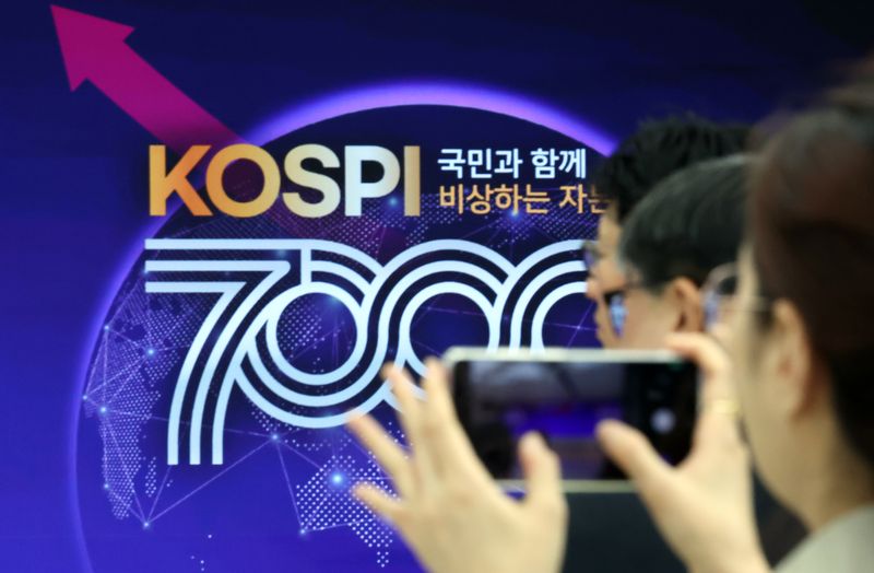 [부산=뉴시스] 하경민 기자 = 사상 처음으로 코스피 7000p를 돌파한 6일 부산 남구 부산국제금융센터 내 한국거래소 홍보관에서 열린 축하행사에 참석한 한 관계자가 휴대전화로 촬영하고 있다. 2026.05.06. yulnetphoto@newsis.com