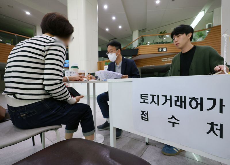 [서울=뉴시스] 배훈식 기자 = 다주택자 양도 소득세 중과 면제 종료일인 9일 오후 서울 송파구청 1층 로비에 마련된 토지거래허가 접수처를 찾은 한 시민이 부동산정보과 담당자와 상담하고 있다. 국토교통부가 이날 오후 6시까지 관련 서류를 제출하고 최대 11월까지 양도 절차를 마무리하면 양도세 중과를 면제키로 하면서 서울 25개 구청이 휴일임에도 문을 열었다 2026.05.09. dahora83@newsis.com