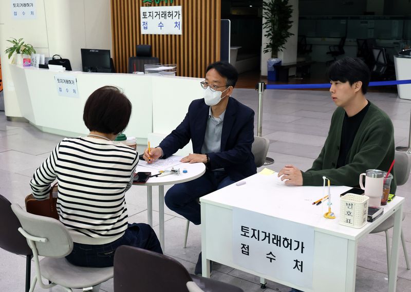 [서울=뉴시스] 배훈식 기자 = 다주택자 양도 소득세 중과 면제 종료일인 9일 오후 서울 송파구청 1층 로비에 마련된 토지거래허가 접수처를 찾은 한 시민이 부동산정보과 담당자와 상담하고 있다. 국토교통부가 이날 오후 6시까지 관련 서류를 제출하고 최대 11월까지 양도 절차를 마무리하면 양도세 중과를 면제키로 하면서 서울 25개 구청이 휴일임에도 문을 열었다 2026.05.09. dahora83@newsis.com