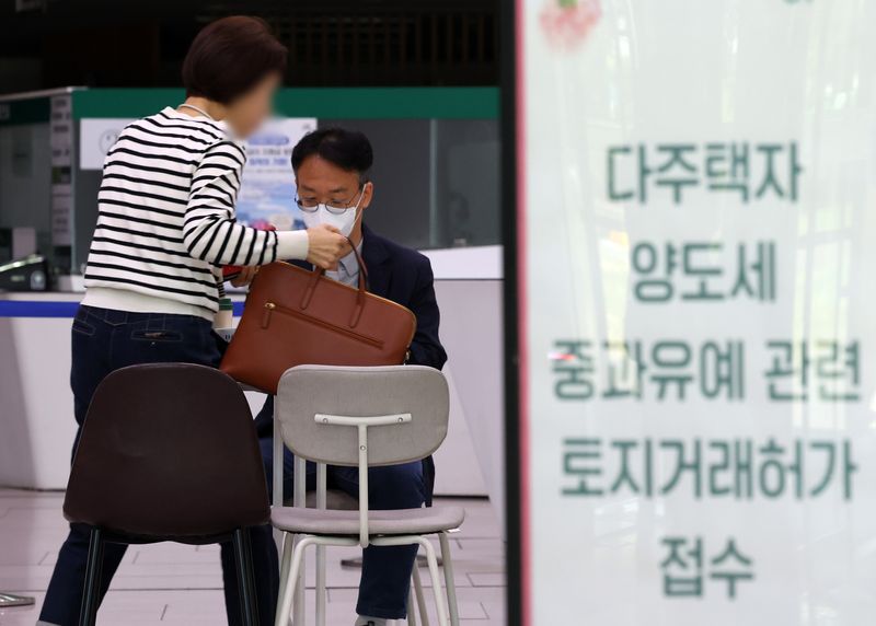 [서울=뉴시스] 배훈식 기자 = 다주택자 양도 소득세 중과 면제 종료일인 9일 오후 서울 송파구청 1층 로비에 마련된 토지거래허가 접수처를 찾은 한 시민이 부동산정보과 담당자와 상담하고 있다. 국토교통부가 이날 오후 6시까지 관련 서류를 제출하고 최대 11월까지 양도 절차를 마무리하면 양도세 중과를 면제키로 하면서 서울 25개 구청이 휴일임에도 문을 열었다 2026.05.09. dahora83@newsis.com