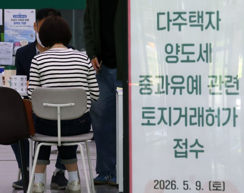 [서울=뉴시스] 배훈식 기자 = 다주택자 양도 소득세 중과 면제 종료일인 9일 오후 서울 송파구청 1층 로비에 마련된 토지거래허가 접수처를 찾은 한 시민이 부동산정보과 담당자와 상담하고 있다. 국토교통부가 이날 오후 6시까지 관련 서류를 제출하고 최대 11월까지 양도 절차를 마무리하면 양도세 중과를 면제키로 하면서 서울 25개 구청이 휴일임에도 문을 열었다 2026.05.09. dahora83@newsis.com