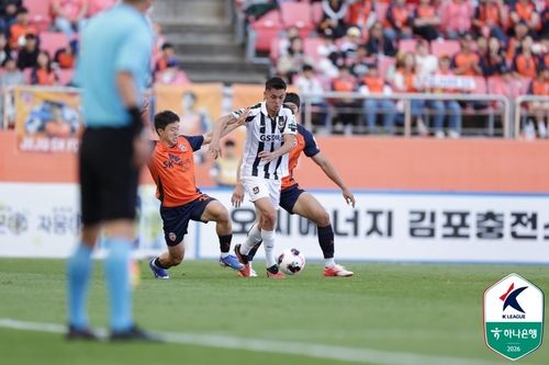 제주 선수 사이에서 공을 모는 서울 후이즈(가운데). (출처=연합뉴스)