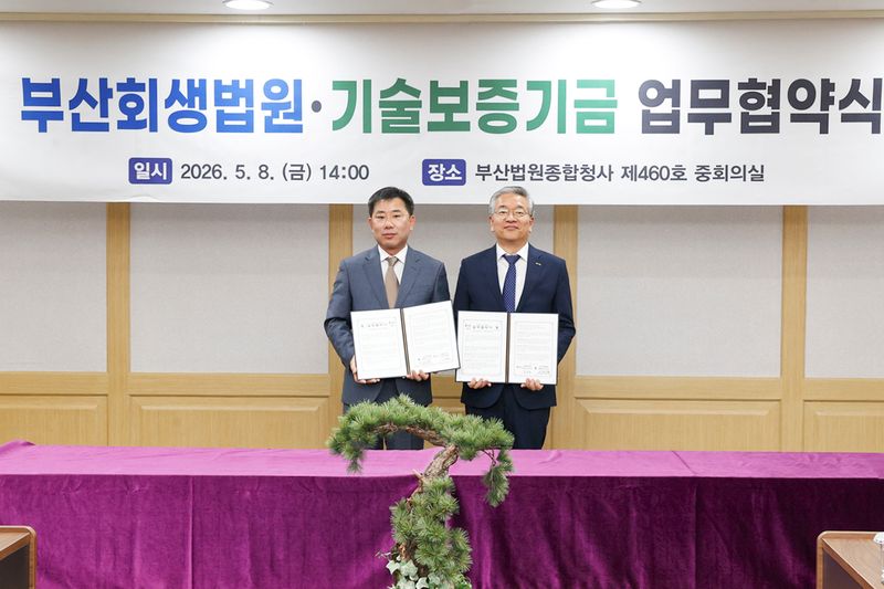 김종호 기술보증기금 이사장(오른쪽)과 성익경 부산회생법원장이 업무협약 후 기념촬영을 하고 있다. 기술보증기금 제공