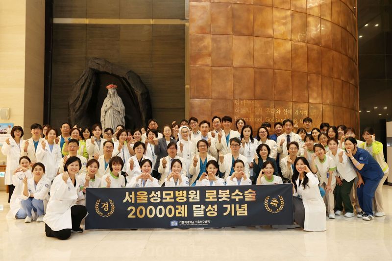 11일 서울성모병원 본관 1층 로비 성당 앞에서 병원장 이지열 교수, 김혜경 간호부원장 등 주요 보직자와 전임 로봇수술센터장인 산부인과 김미란 교수, 위장관외과 송교영 교수를 비롯해 현임 로봇수술센터장인 홍성후 교수 등 여러 교직원들이 기념사진을 촬영하고 있다. 서울성모병원 제공