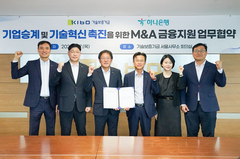 기술보증기금과 하나은행이 '기업승계 및 기술혁신 촉진을 위한 M&A 금융지원 업무협약(MOU)'을 맺고 기념촬영을 하고 있다.