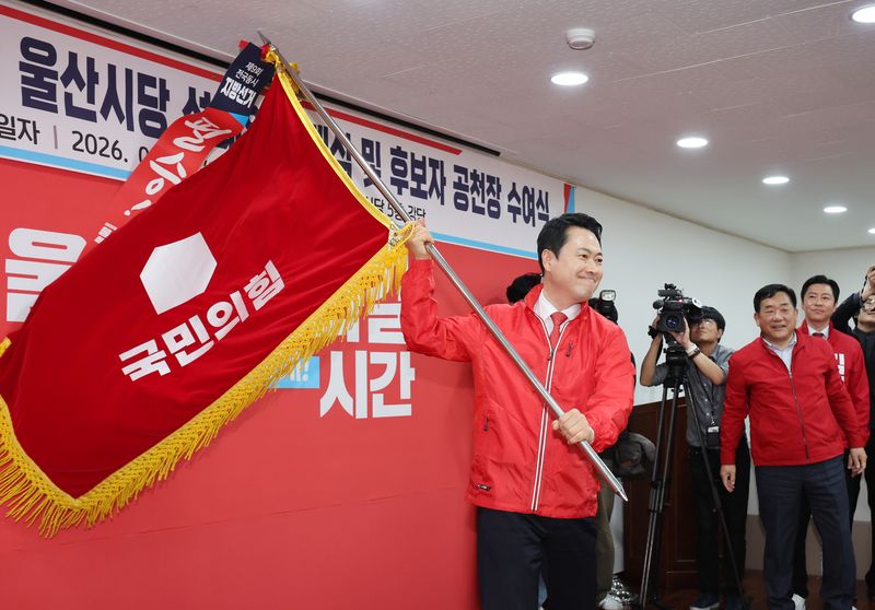 국민의힘 장동혁 대표가 11일 울산시 남구 울산시당에서 열린 '6·3 지방선거 울산선대위 발대식 및 공천장 수여식'에 참석해 당기를 흔들고 있다. 연합뉴스
