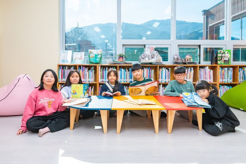 KB국민은행이 올해까지 143곳의 'KB작은도서관'을 조성하는 등 문화 인프라 확대에 나서고 있다. 지난 2월 전북 완주 '구이모악 작은도서관'에서 아이들이 책을 보며 기념촬영을 하고 있다. KB금융그룹 제공