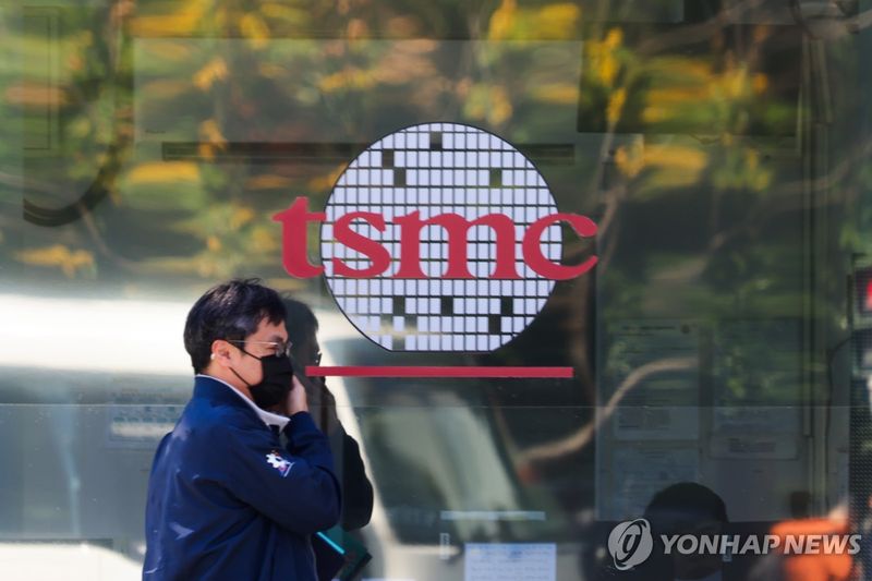 TSMC 로고 앞을 지나는 행인 (출처=연합뉴스)