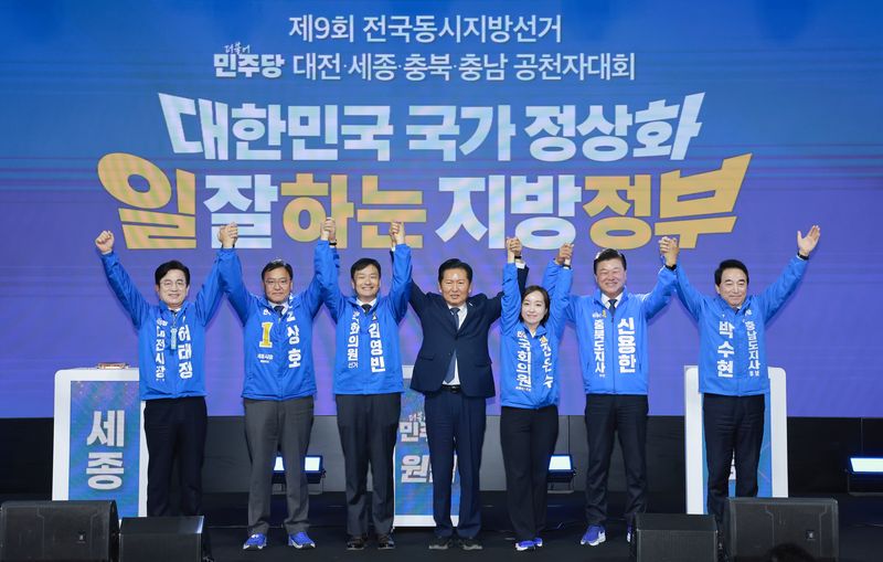 충북 청주시 엔포드호텔에서 12일 열린 6·3지방선거 더불어민주당 대전·세종·충북·충남 공천자대회에서 정청래 대표(가운데)와 충청권 광역단체장 예비후보들이 손을 맞잡고 있다. 연합뉴스