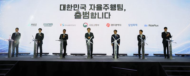 한지형 오토노머스 A2Z 대표(왼쪽부터), 박민우 현대차·기아 AVP본부장(사장), 정용식 한국교통안전공단 이사장, 김윤덕 국토교통부 장관, 강기정 광주광역시장, 이문화 삼성화재 사장, 박중희 라이드플럭스 대표가 13일 광주 김대중컨벤션센터에서 열린 업무협약식에 참석해 서명을 위해 연단에 서 있다. 현대차그룹 제공.