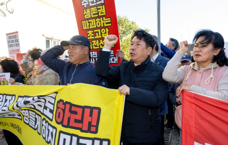 [제천=뉴시스] 이병찬 기자 = 27일 한국전력 충북강원지사 앞에서 열린 집회에서 김창규(가운데) 제천시장이 시민들과 함께 신평창~신원주 초고압 송전선로 제천 경유 계획 백지화를 요구하고 있다.(사진=제천시 제공)2025.10.27.photo@newsis.com