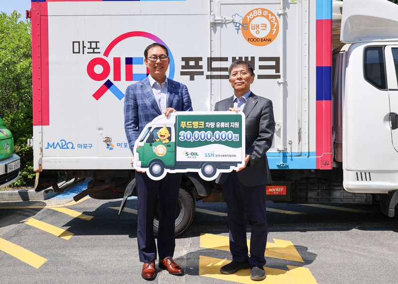에쓰오일 이건명 본부장(왼쪽)과 한국사회복지협의회 조남권 사무총장이 14일 서울 마포푸드뱅크 1호점에서 개최된 농어촌 지역 식품나눔 차량 유류비 전달식에서 기념 촬영을 하고 있다. 에쓰오일 제공