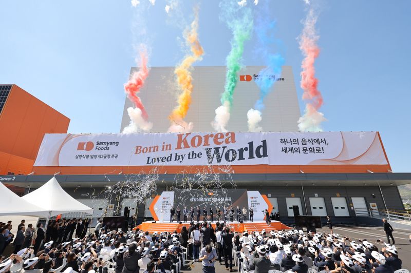 [서울=뉴시스] 김정수 삼양식품 부회장이 11일 경남 삼양식품 밀양캠퍼스에서 열린 밀양 제2공장 준공식에 참석해 참석자들과 세리머니를 하고 있다.삼양식품은 연면적 3만 2989㎡, 지하 1층, 지상 3층 규모의 밀양 2공장을 준공했다. 해외 수출용 제품을 생산하는 제2공장이 가동되면 미국과 멕시코, 유럽 등 주요 해외시장에 대한 초과 수요 대응이 가능할 것이라는 전망이다. (사진=삼양식품 제공) 2025.06.11. photo@newsis.com *재판매 및 DB 금지