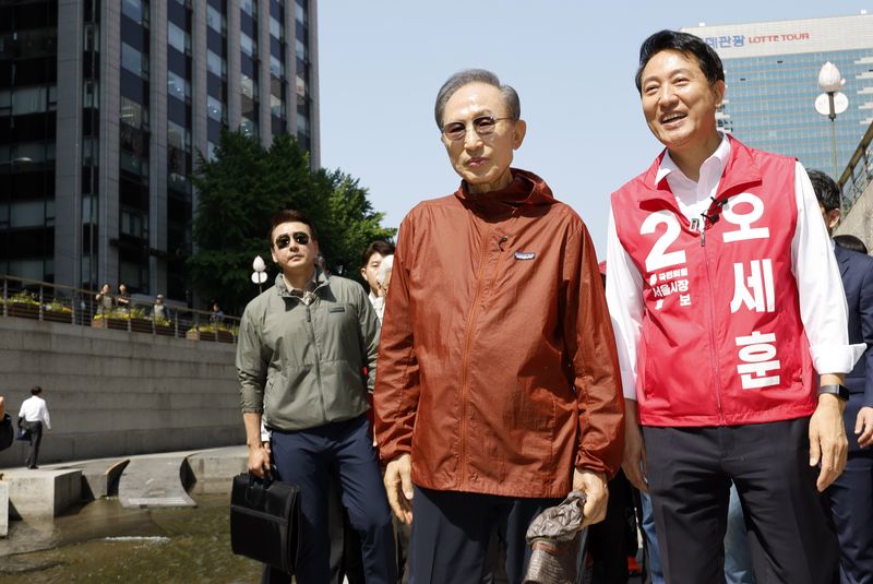 오세훈 국민의힘 서울시장 후보가 15일 서울 중구 청계천에서 이명박 전 대통령과 만나 지지자들을 향해 인사를 하고 있다. 뉴시스