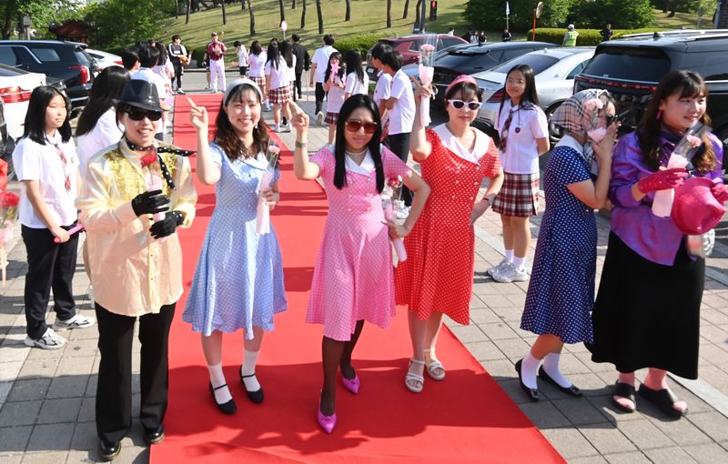 [수원=뉴시스] 김종택기자 = 스승의날인 15일 경기 수원시 팔달구 매향중학교에서 열린 '추억의 책가방' 행사에서 복고풍 복장을 한 선생님들이 학생들의 축하와 응원속에 레드카펫을 밟으며 행진하고 있다. 2026.05.15. jtk@newsis.com