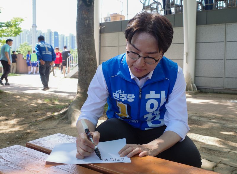 하정우 더불어민주당 부산 북구갑 국회의원 보궐선거 후보가 17일 부산 북구 화명생태공원에서 열린 북구축구협회장기 대회 현장에서 한 주민에게 사인을 해주고 있다. 2026.05.17 ⓒ 뉴스1 김세정 기자