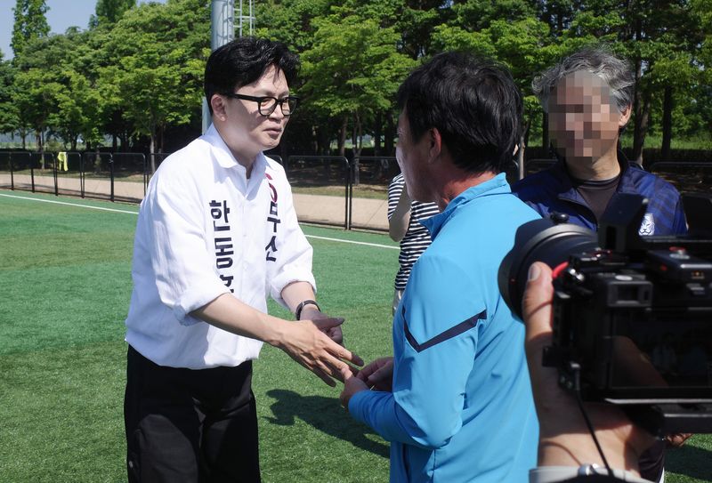 한동훈 무소속 부산 북구갑 국회의원 보궐선거 후보가 17일 부산 북구 화명생태공원에서 열린 북구축구협회장기 대회 현장에서 주민들과 인사하고 있다. 2026.05.17 ⓒ 뉴스1 김세정 기자