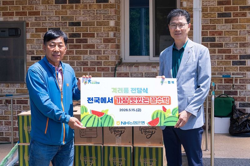 강태영 NH농협은행장(오른쪽)이 지난 15일 춘천시 동산면 구암마을에서 원창1리 김봉림 이장에 수박을 전달한 뒤 기념촬영을 하고 있다. 농협은행 제공