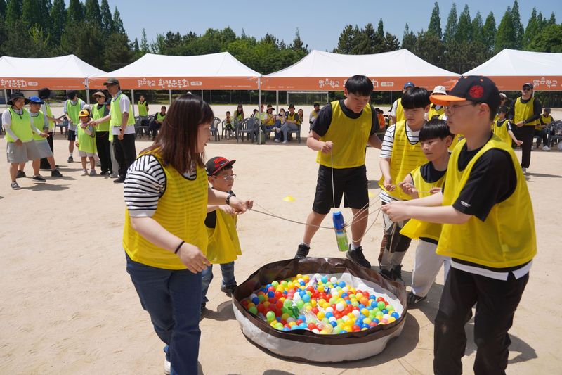 한화그룹이 진행한 '맑은학교 환경운동회'에 참가한 경남 지역 가족과 초등학생이 쓰레기를 낚아 올리는 '분리배출 낚시왕' 프로그램을 즐기고 있다. 한화그룹 제공
