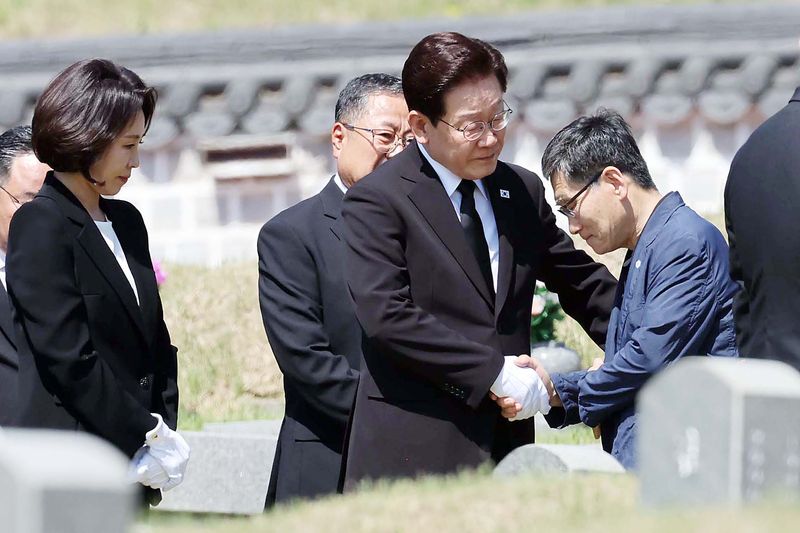 이재명 대통령이 18일 광주 북구 국립5·18민주묘지에서 고 양창근 열사 묘소를 찾아 참배한 뒤 유가족을 위로하고 있다. 뉴시스