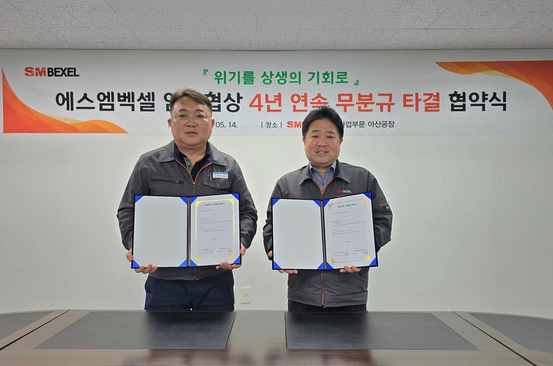 유병선 SM백셀 자동차사업부문 대표(오른쪽)와 이재진 노동조합 위원장이 지난 14일 충남 아산시 도고공장에서 열린 '2026년도 임금 및 단체 협약' 체결식에서 기념촬영을 하고 있다. SM그룹 제공