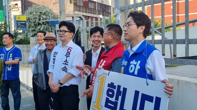 하정우 민주당 후보와 한동훈 무소속 후보가 지난 19일 구포동 인근에서 산악회 회원들을 배웅하고 있다. 사진=이해람 기자