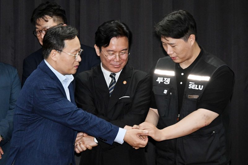 20일 경기도 수원시 장안구 경기고용노동청에서 열린 삼성전자 임금협상을 마친 후 여명구 삼성전자 DS(디바이스솔루션·반도체 사업 담당) 피플팀장과 김영훈 고용노동부 장관, 최승호 삼성그룹 초기업노동조합 삼성전자지부 위원장이 잠정 합의한에 서명한 후 손을 맞잡고 있다. (공동취재) 2026.5.20 ⓒ 뉴스1 김영운 기자