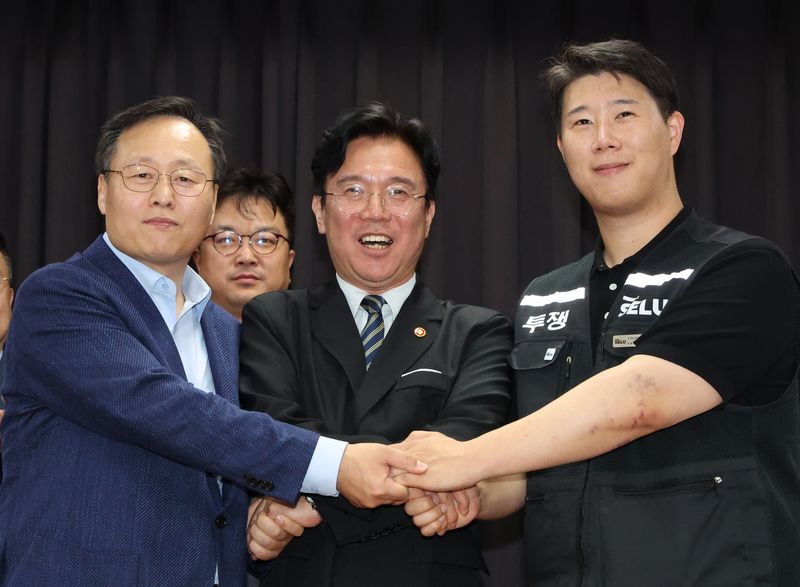 지난 5월 20일 경기 수원시 장안구 경기고용노동청에서 열린 삼성전자 임금협상을 마친 후 여명구 삼성전자 DS(디바이스솔루션·반도체 사업 담당) 피플팀장(왼쪽부터)과 김영훈 고용노동부 장관, 최승호 삼성그룹 초기업노동조합 삼성전자지부 위원장이 잠정 합의한에 서명한 후 손을 맞잡고 파이팅을 외치고 있다. 공동취재