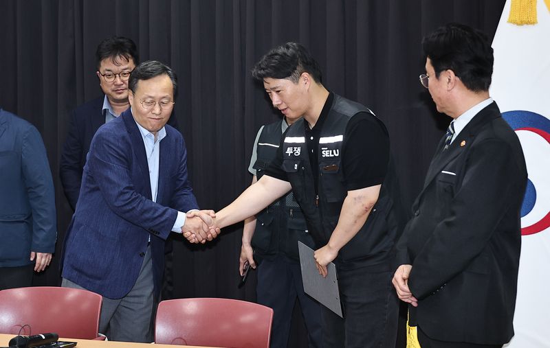 20일 경기 수원시 장안구 경기고용노동청에서 열린 삼성전자 임금협상을 마친 후 여명구 삼성전자 DS(디바이스솔루션·반도체 사업 담당) 피플팀장과 최승호 삼성그룹 초기업노동조합 삼성전자지부 위원장이 악수를 하고 있다. (공동취재) 2026.5.20 ⓒ 뉴스1 김영운 기자