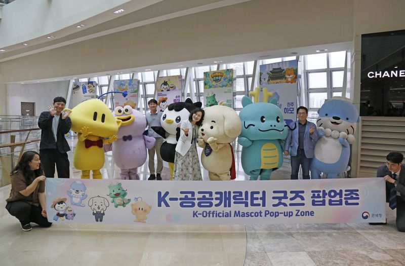 이진희 관세청 통관국장(가운데)이 21일 서울 롯데면세점 월드타워점에 마련된 K-공공캐릭터 굿즈 팝업존에서 행사에 참여한 지자체 관계자 및 캐릭터들과 기념촬영을 하고 있다. 관세청 제공