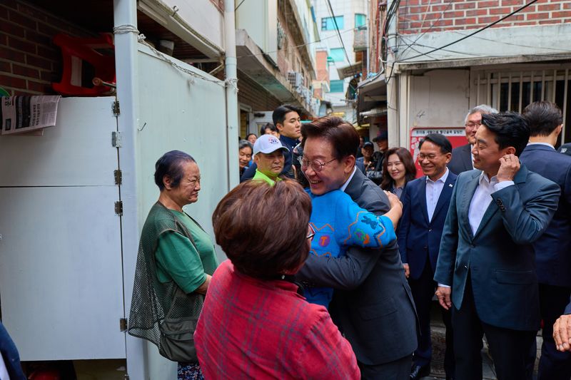 이재명 대통령이 21일 서울 종로구 돈의동 쪽방촌을 방문해 주민들과 인사를 나누고 있다. 청와대 제공