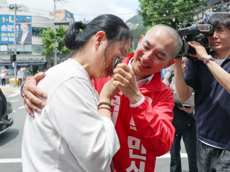 박민식 국민의힘 부산 북구갑 국회의원 보궐선거 후보가 22일 부산 북구 신만덕교차로 일대에서 거리 유세를 하던 중 눈물을 흘리는 시민의 응원을 받으며 눈물을 닦아주고 있다. 뉴시스
