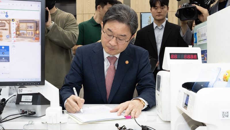 이억원 금융위원장이 22일 서울 종로구 NH농협은행 정부서울청사지점에서 국민참여성장펀드를 가입하고 있다. 국민참여성장펀드는 국민자금을 모아 공모펀드(3개)를 조성하고, 공모펀드가 다시 여러 자펀드(10개)에 투자하는 구조다. (공동취재) 2026.5.22 ⓒ 뉴스1 김성진 기자